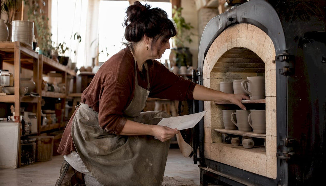 Ceramicist loading mugs into kiln