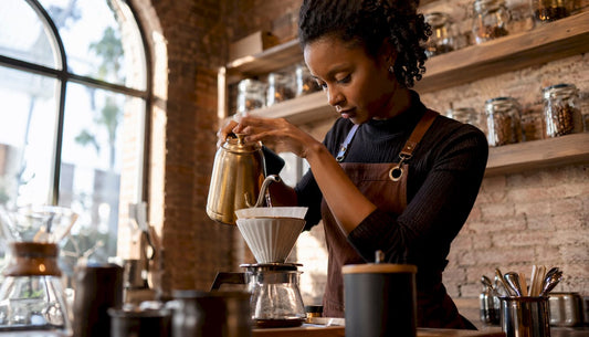 Female barista making artisan pour-over coffee