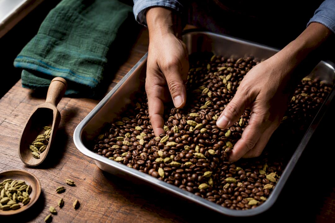 Roasted beans mixed with cardamom pods