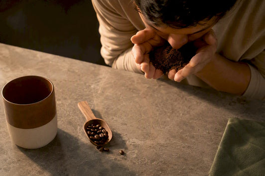 Hands smelling freshly ground coffee